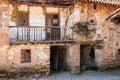 Old worn-out stone house, balcony, wooden doors. Carmona, Cantabria, Spain