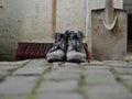 Dirty shoes, a shovel and a push broom Royalty Free Stock Photo