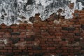 Old and worn red brick wall face with white and black cement coating peeling away Royalty Free Stock Photo