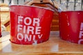 Old and worn red fire buckets in wooden stand Royalty Free Stock Photo