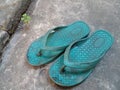 Old and worn rubber sandals. Slippers on the cement floor. Royalty Free Stock Photo