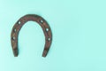 Old worn rusty horseshoe on blue background