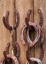 Old worn rusty horseshoes displayed on wall of stables - visitors can take them as luck symbol Royalty Free Stock Photo