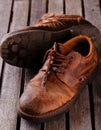 Old worn shoes on grey wooden board Royalty Free Stock Photo