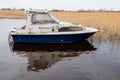 Old worn small fishing boat on a calm water in a lake. Cloudy sky. Nobody. Small river vessel. Hobby and transportation concept Royalty Free Stock Photo