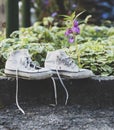 Old worn white textile shoes with untied laces