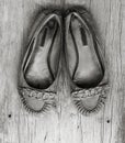 Old worn women's shoes made of genuine leather on old gray wooden board with cracks Royalty Free Stock Photo