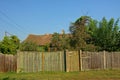 Old worn wooden fence around a farm with orchard in the Romanian countryside