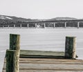 Old worn wooden pier locked on thick sea ice