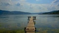 Old worn wooden pier in the rippling water of Danube river