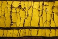 Old worn yellow inscription on a brown t-shirt. Grunge background. Macro shooting.