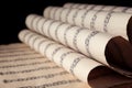 Old wrapped sheets with music notes on black, closeup Royalty Free Stock Photo