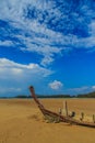 Old wreck fishing boat buried in the sand with blue sky on cloud Royalty Free Stock Photo