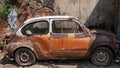 Old wrecked FIAT car with vintage brick