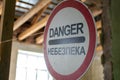 Old wrecked house with 'Danger' in English and in Ukrainian warning sign, abandoned building, uninhabitable place