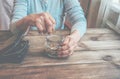 Old wrinkled hand holding jar with coins, empty wallet, wooden background. Royalty Free Stock Photo