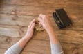 Old wrinkled hand holding jar with coins, empty wallet, wooden background. Royalty Free Stock Photo