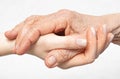 Old wrinkled hand lies on the young hand close-up. Helping for the elderly concept