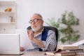 Old male writer sitting at workplace Royalty Free Stock Photo