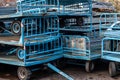 Old written-off blue metal trolleys in a pile dump