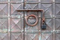 An old wrought iron door knocker, a metal latch and a lock on an old metal door in the Russian style. Royalty Free Stock Photo