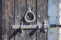 An old wrought iron door knocker, a metal latch and a lock on an old wooden door in the Russian style. Royalty Free Stock Photo