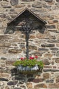 Handicraft wrought iron cross against old stone facade of Farm in Belgium Royalty Free Stock Photo