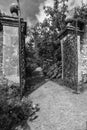 Old wrought iron full size garden gate and brick wall in black a Royalty Free Stock Photo
