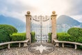 Old wrought-iron gate on Lake Lugano banks in Parco Civico Ciani public garden and dramatic light in Lugano Switzerland