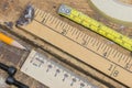 Old yard stick, rulers and tape measures on workshop table with