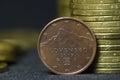 An old, 2009 year, two euro cent coin put on edge in front of piles of coins Royalty Free Stock Photo