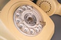 Old yellow antique rotary telephone with removed handset receiver on grey background. Vintage landline home phone with Royalty Free Stock Photo