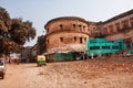 Old yellow auto rickshaw drive past the walls of Ramnagar Fort in Varanasi Royalty Free Stock Photo