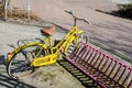 Old yellow bicycle in pink bicycle stands