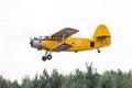 Old yellow biplane take off over forest Royalty Free Stock Photo