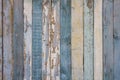 Old yellow blue white wooden wall fence of wooden boards with peeling paint. vertical lines. rough surface texture Royalty Free Stock Photo