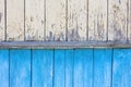 An old yellow and blue wooden wall of a house with cracked peeling oil paint. Royalty Free Stock Photo