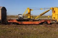 Old yellow cargo crane wagon on abandoned train tracks