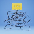 Old yellow cassette with the ribbon tangled underneath