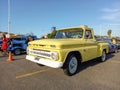 Old yellow 1965 Chevrolet Chevy C10 Apache Flareside bed pickup truck in a parking.