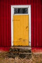 old yellow doors with a window against the red walls Royalty Free Stock Photo