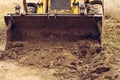 An old yellow excavator helps to set up the road in the village