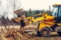 An old yellow excavator helps to set up the road in the village