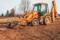 An old yellow excavator helps to set up the road in the village