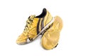 Old yellow futsal sports shoes and the insole is damaged on white background football sportware object isolated