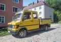 Old rusty yellow van or light delivery truck Mercedes_Benz car parked.