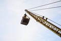 Old yellow mechanical clamshell grab on blue sky background