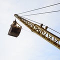 Old yellow mechanical clamshell grab on blue sky background