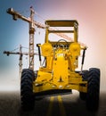 Old yellow motor grader on the road Royalty Free Stock Photo