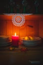 Old yellow painted cupboard with candles, a vase with red roses, autumn leaves and crocheted doilies Royalty Free Stock Photo